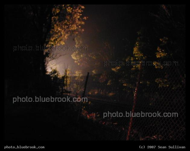 Emergence - Lights from an MBTA commuter rail train illuminate the track, Needham MA