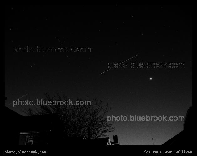Discovery and Venus - Space shuttle Discovery (STS-120) moves across the sky during a 15-second exposure from Somerville MA.  Venus is the bright object, and an airplane is also visible to the left.