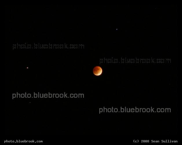 Midnight Eclipse - The moon with stars during a total lunar eclipse.  Saturn is above and to the right, while the bright star Regulus is to the left.  Revere Beach, MA