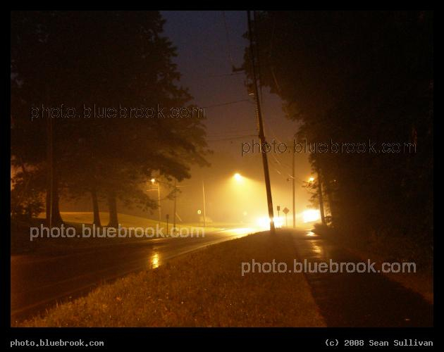 East Pleasant Street - On a rainy evening, the illumination cone beneath a streetlamp is visible in the moist air, while the fading color of the day's blue sky remains visible above.  Amherst MA