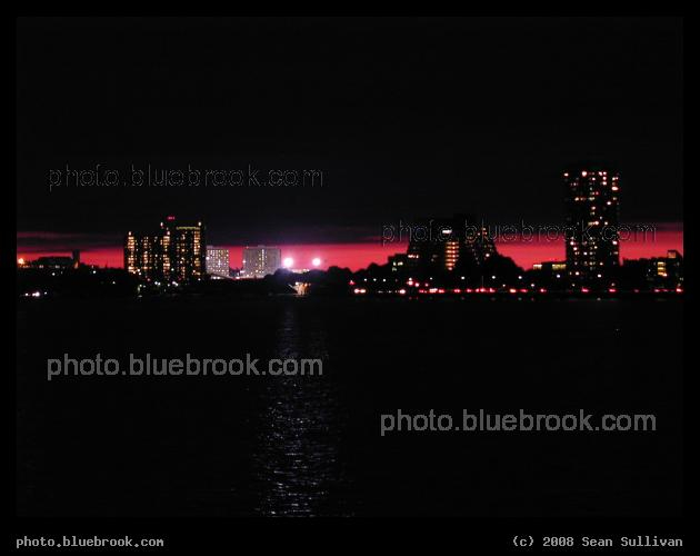 City - Looking across the Charles River shortly after sunset on a cloudy day, with evening colors shining through a thin strip of clear sky on the horizon.  Cambridge MA