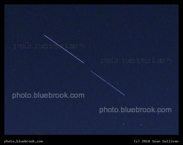 Orbital Pair - The space station (above) and space shuttle Endeavour (below), hours after Endeavour undocked from the station on flight STS-130, appear as streaks moving against the starry background of Delphinus in this eight-second exposure from Somerville MA