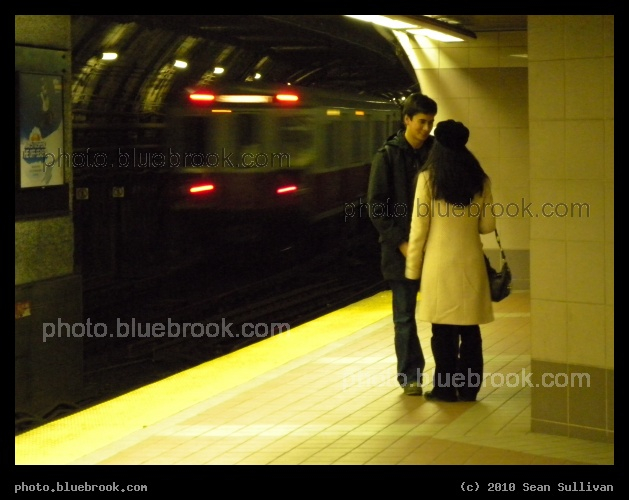 Waiting for the Train - An outbound Red Line subway train passes behind passengers on the inbound platform at South Station, Boston MA