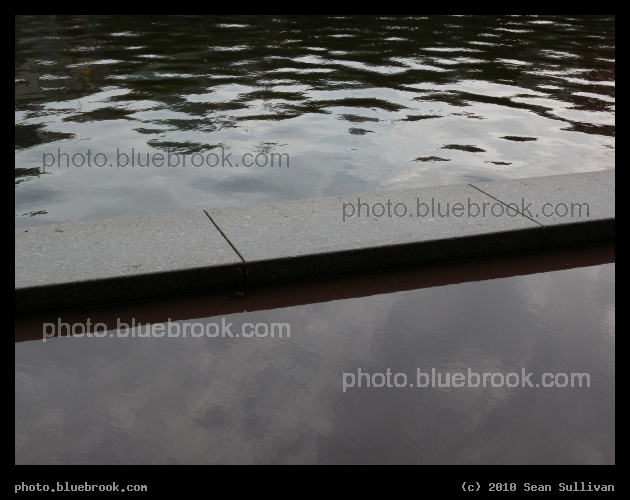Walkway through the Water - After an afternoon rainstorm, an ornamental ridge separates a flooded sidewalk (near side) and a canal (far side).  Outside the CambridgeSide Galleria, Cambridge MA