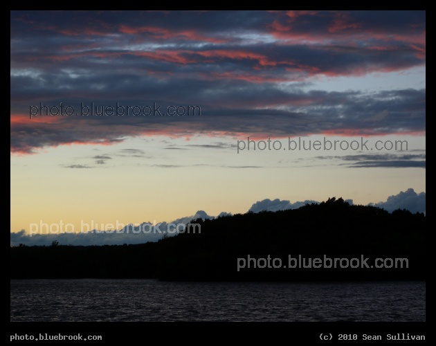 Last Rays of Sunset - The last reddish light of sunset highlights the edges of clouds over Fresh Pond, Cambridge MA
