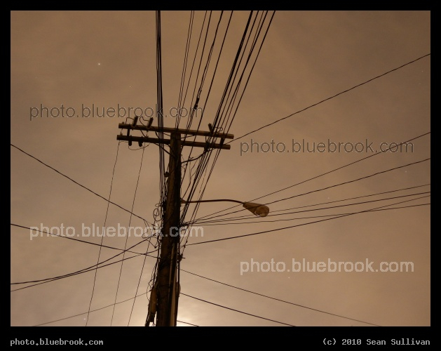 Darkness of the Light - A lamppost at night during a neighborhood blackout, with some illumination from the moon (behind the pole).  Somerville, MA