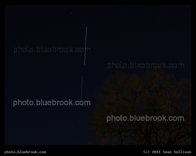 Completion - This 10-second exposure from Somerville MA shows the International Space Station (top line, trailing) in a finished configuration after the departure of space shuttle Discovery STS-133 (bottom line, leading), entering the Earth