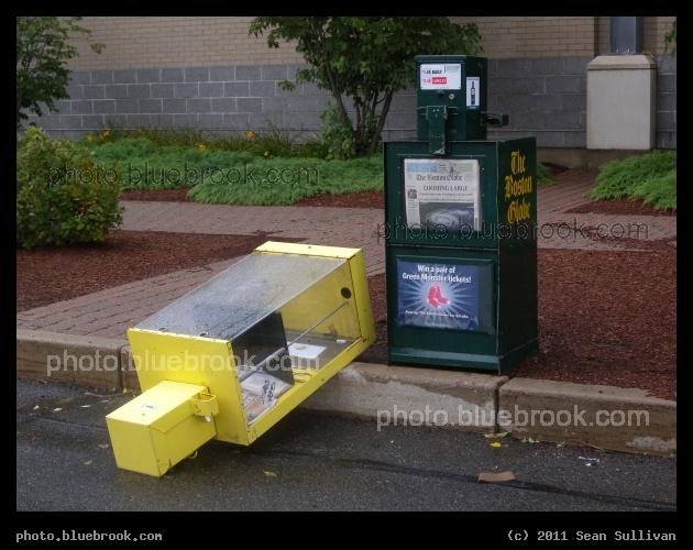 The Fallen - A newspaper rack in Somerville MA blown over during Hurricane Irene, with the surviving rack showing a Boston Globe front-page image of the storm