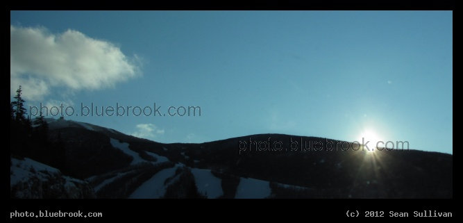 Slipping Behind the Mountain - The sun disappearing from view in the White Mountains, seen from I-93 southbound in New Hampshire