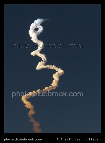 Rocket at Sunset - Launch of navigation satellite GPS II F-6 on a Delta-IV rocket from Cape Canaveral, FL.  Rocket visible as star on right, launch cloud illuminated with colors of sunset.