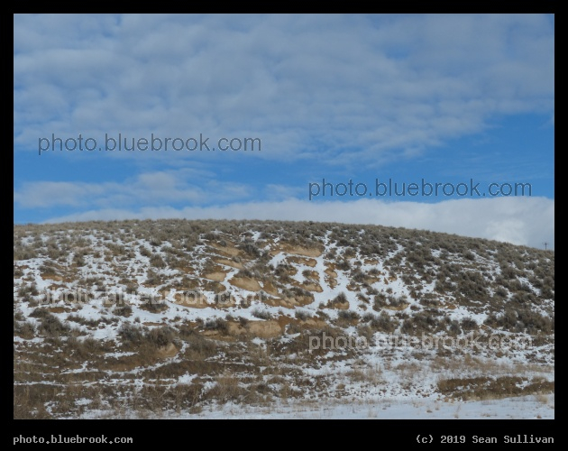 Snow Dusted Hillside under Blue Sky - Corvallis MT